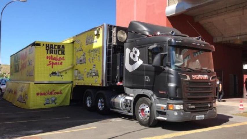 Foto do HackaTruck, um caminhão preto com carroceria amarela