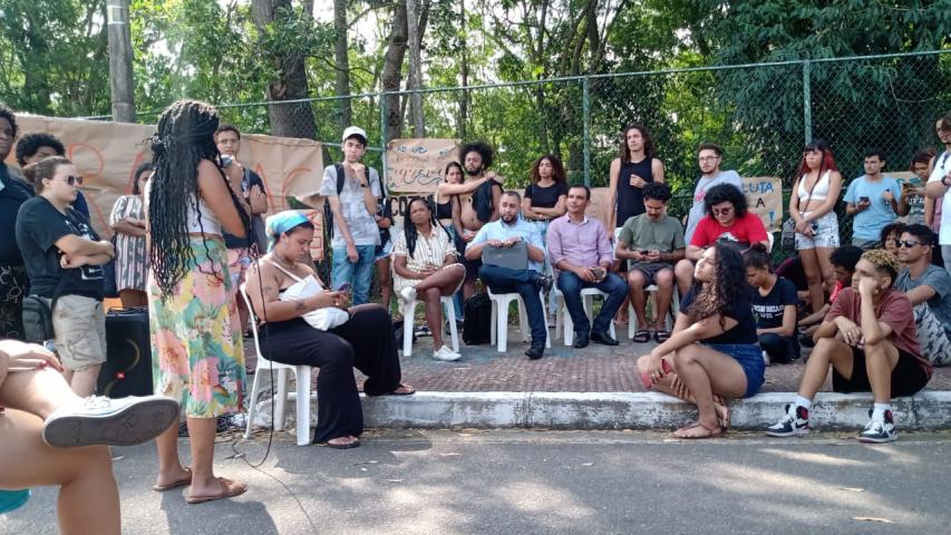Representantes da Ufes, do movimento estudantil e do DCE em reunião ao ar livre, em frente ao portal norte do campus de Goiabeiras.