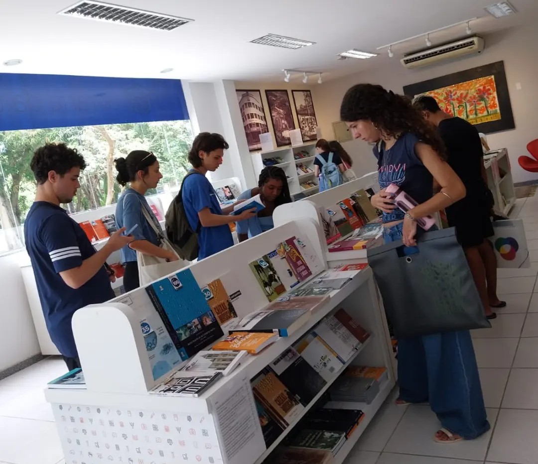 A foto mostra estudantes visitando a livraria da Ufes e olhando os livros