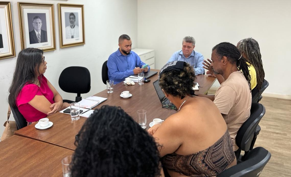 O reitor Eustáquio de Castro na cabeceira da mesa em reunião com sua equipe, juntamente com a vice-reitora Sonia Lopes.