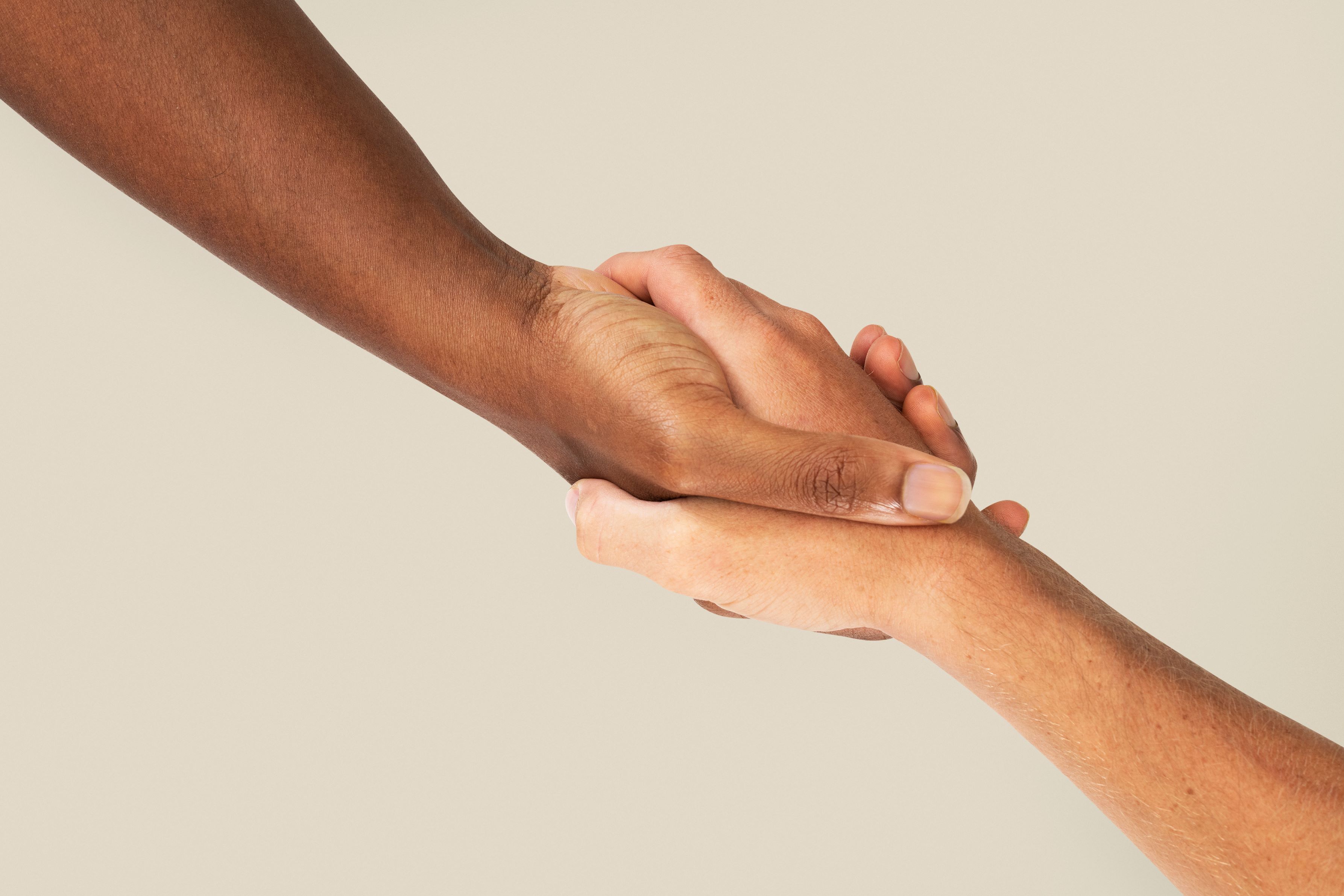 Imagem de duas mãos, uma ajudando a outra, em gesto de caridade