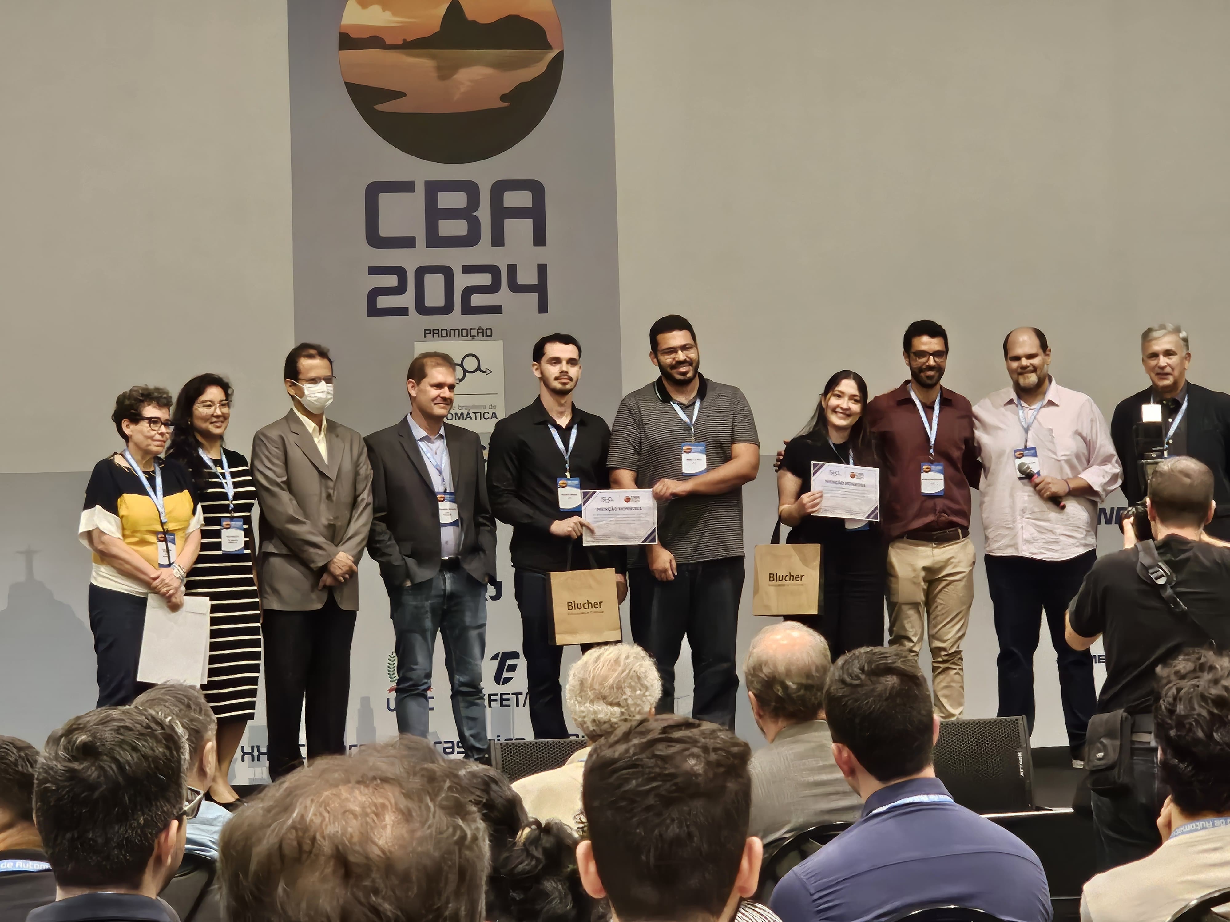 Estudantes da Ufes (os dois no centro da foto) recebem a menção honrosa Foto dos estudantes em solenidade de premiação
