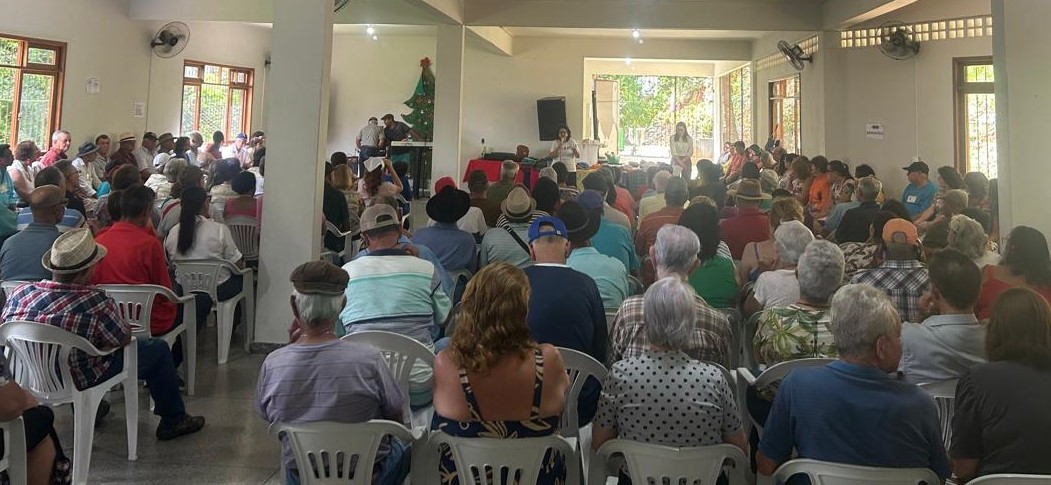 Centro de Convivência do Idoso de Venda Nova do Imigrante Foto do salão lotado do Centro de Convivência do Idoso, com as pessoas sentadas assistindo a uma palestra