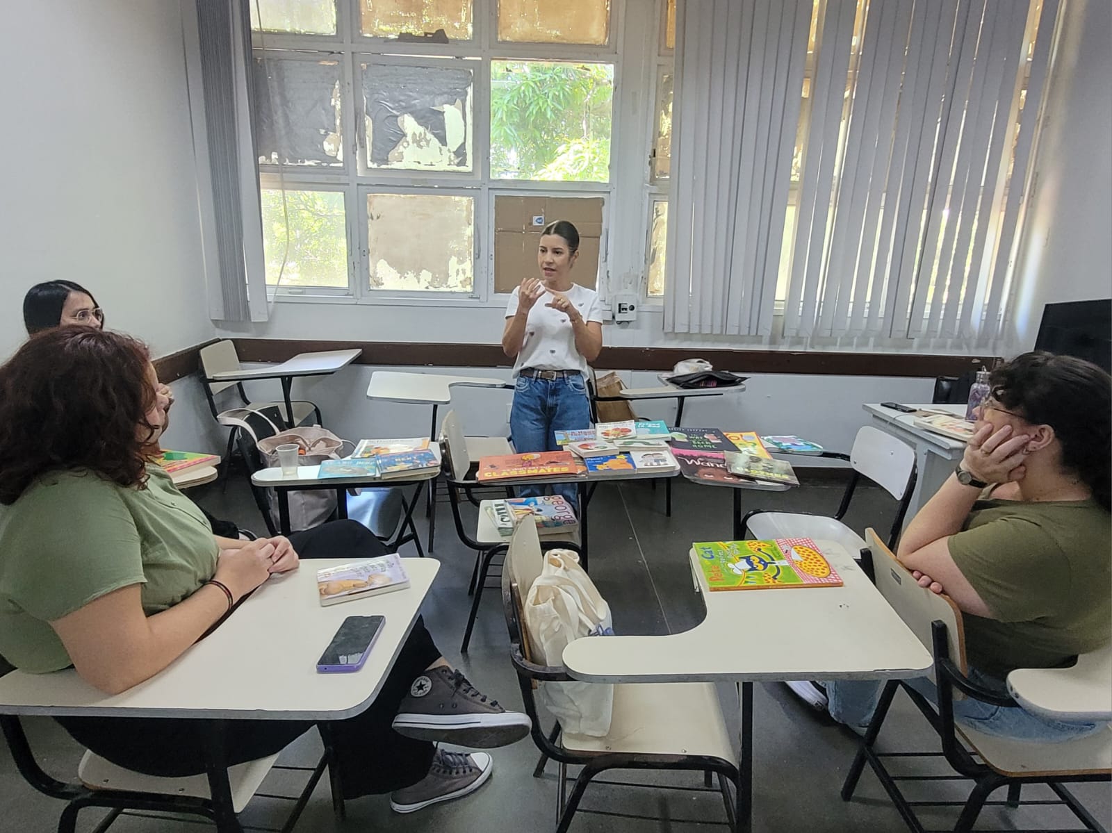 A oficina Experiências Literárias com Crianças na Escola Foto da professora Marianna Merlo ministrando a oficina em uma sala de aula