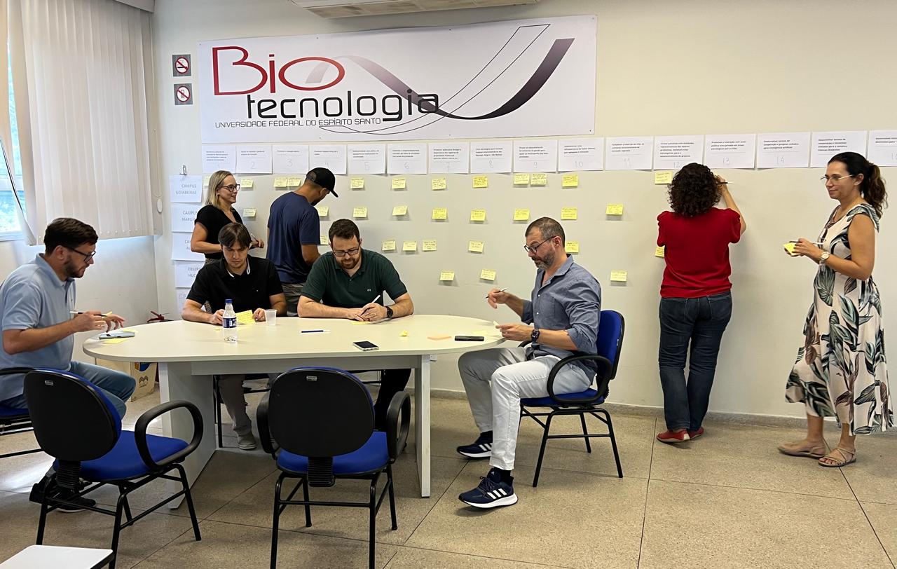 O encontro foi o primeiro de ações semelhantes que irão acontecer nos diferentes campi capitaneadas pela Inova Ufes Grupo de participantes em uma mesa elaborando o planejamento enquanto outras pessoas fixam papeis na parede como parte da atividade