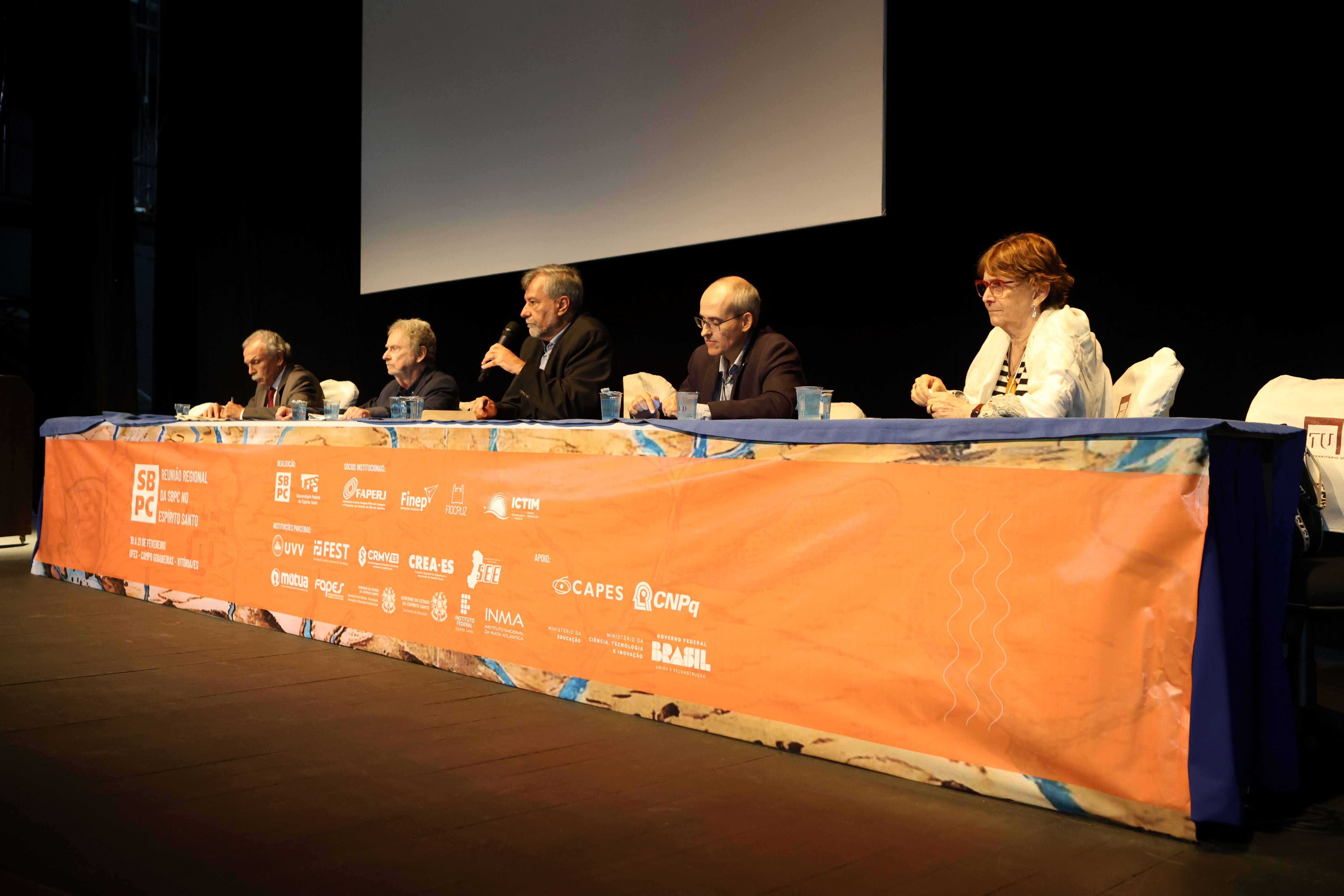 Foto dos especialistas da mesa-redonda sentados à mesa durante as apresentações