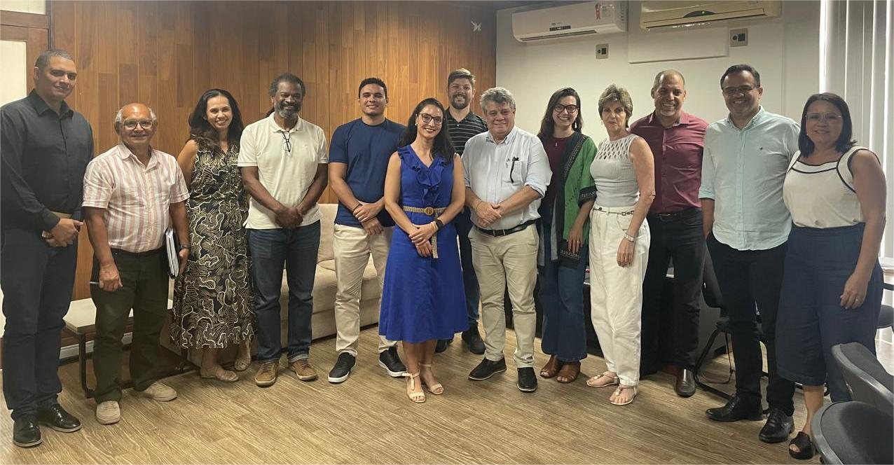 Os membros do Comitê de Governança, Gestão de Riscos e Controles Internos em pé, na sala de reuniões da Reitoria