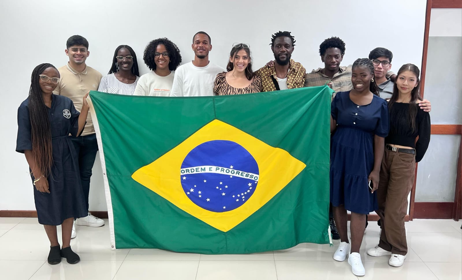 Foto dos estudantes reunidos segurando uma bandeira do Brasil