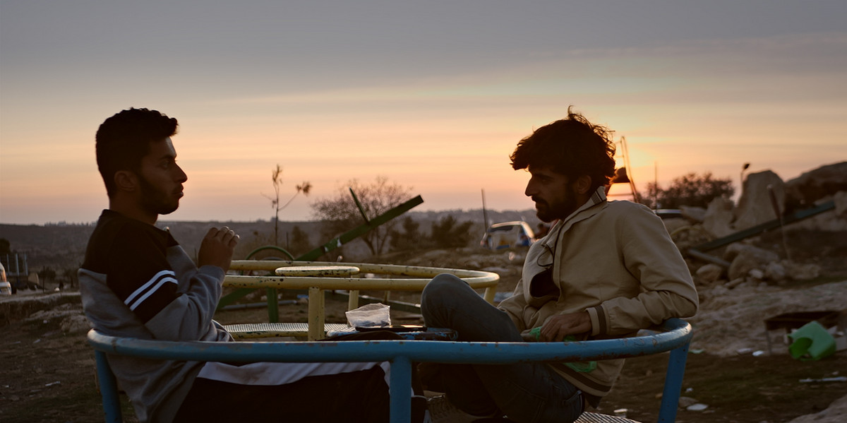 Cena do documentário Sem Chão Cena do documentário Sem Chão, onde os dois personagens aparecem sentados frente a frente, em um lugar que parece um parque destruído