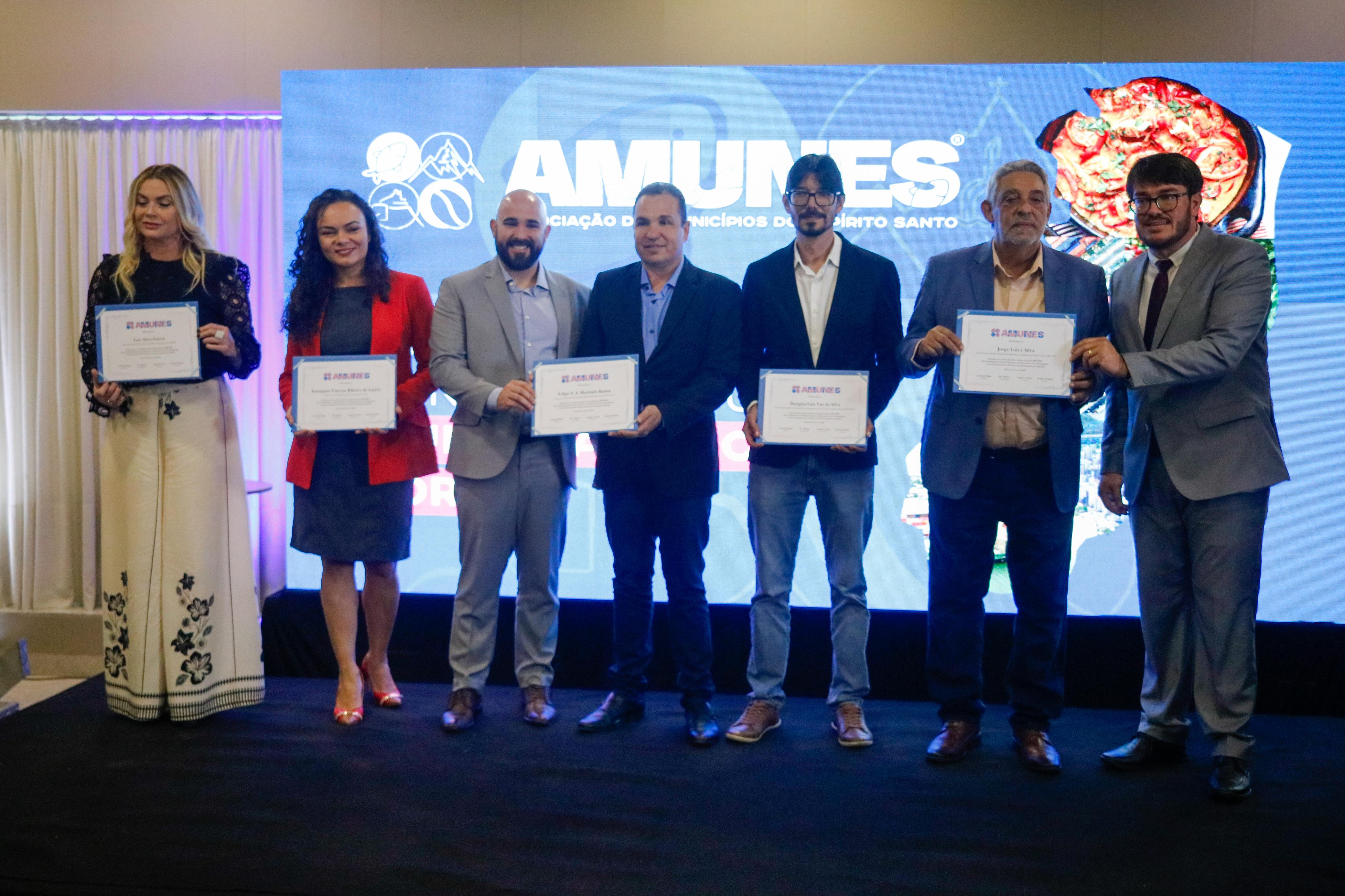 Foto de sete homenageados com os certificados em mãos