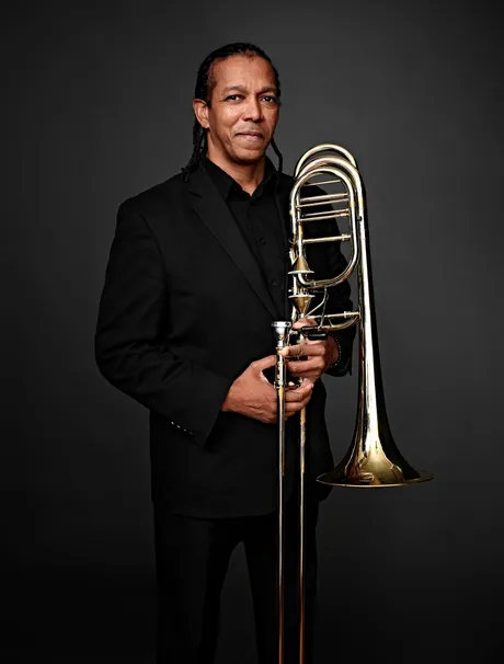 Foto do trombonista norte-americano Darrin C. Milling em pé, segurando o trombone