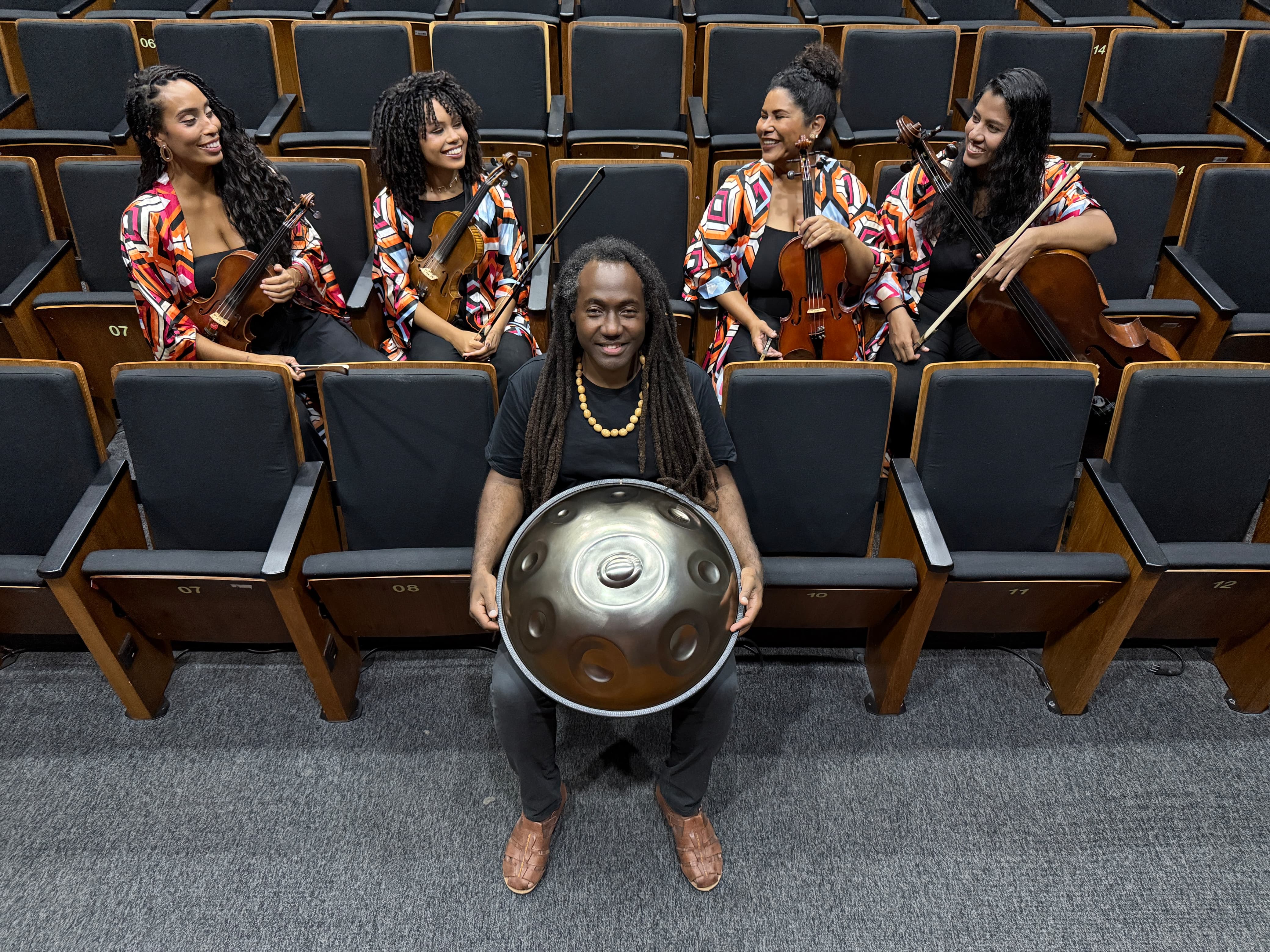 Foto do músico Luccas Martins segurando o handpan e o Quarteto Zuri