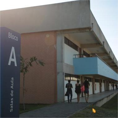 Foto de prédio do campus da Ufes em São Mateus, com totem azul à esquerda indicando em letras brancas &quot;Bloco A - salas de aula&quot;