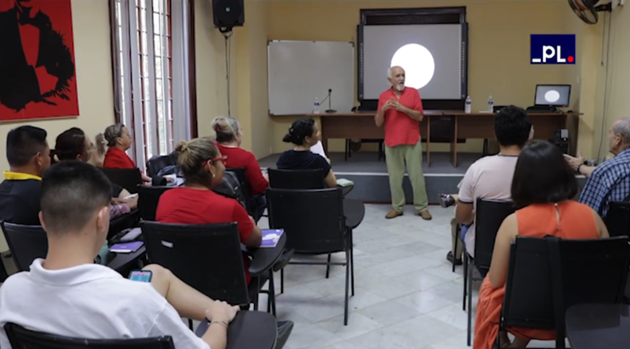 Foto do professor ministrando sua palestra em uma sala com diversas pessoas