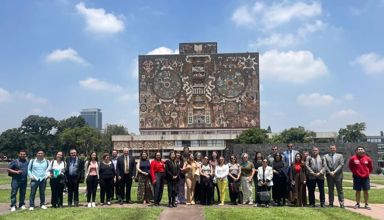 Foto dos gestores em frente a uma universidade mexicana