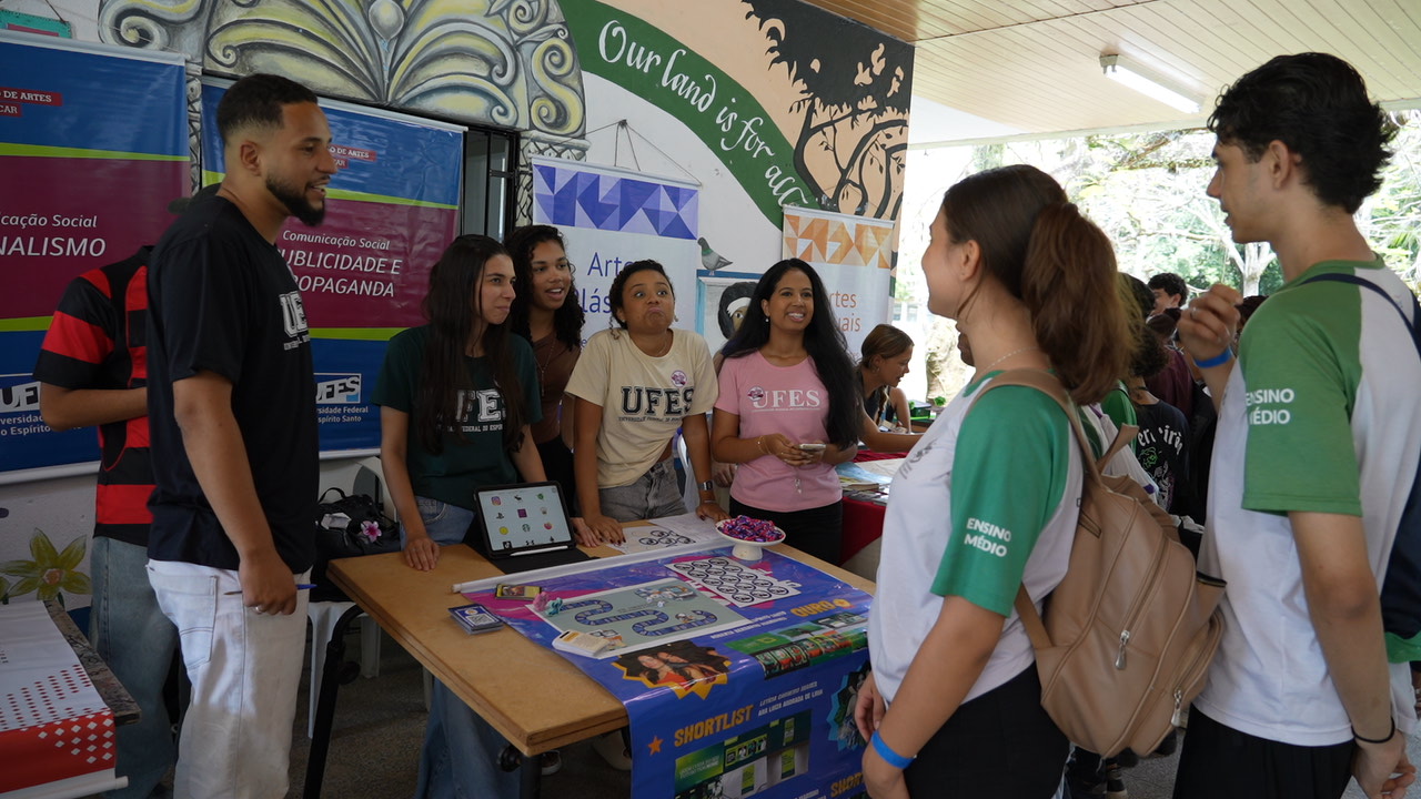 Foto de estudantes no estande do curso de Publicidade e Propaganda