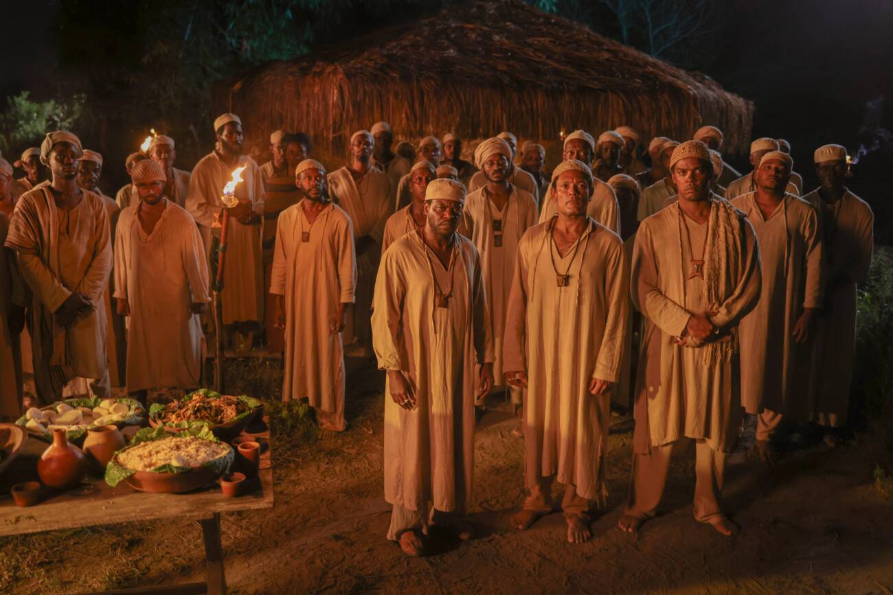 Cena de Malês, na qual aparece um grupo de negros em pé, à noite. Dois seguram tochas