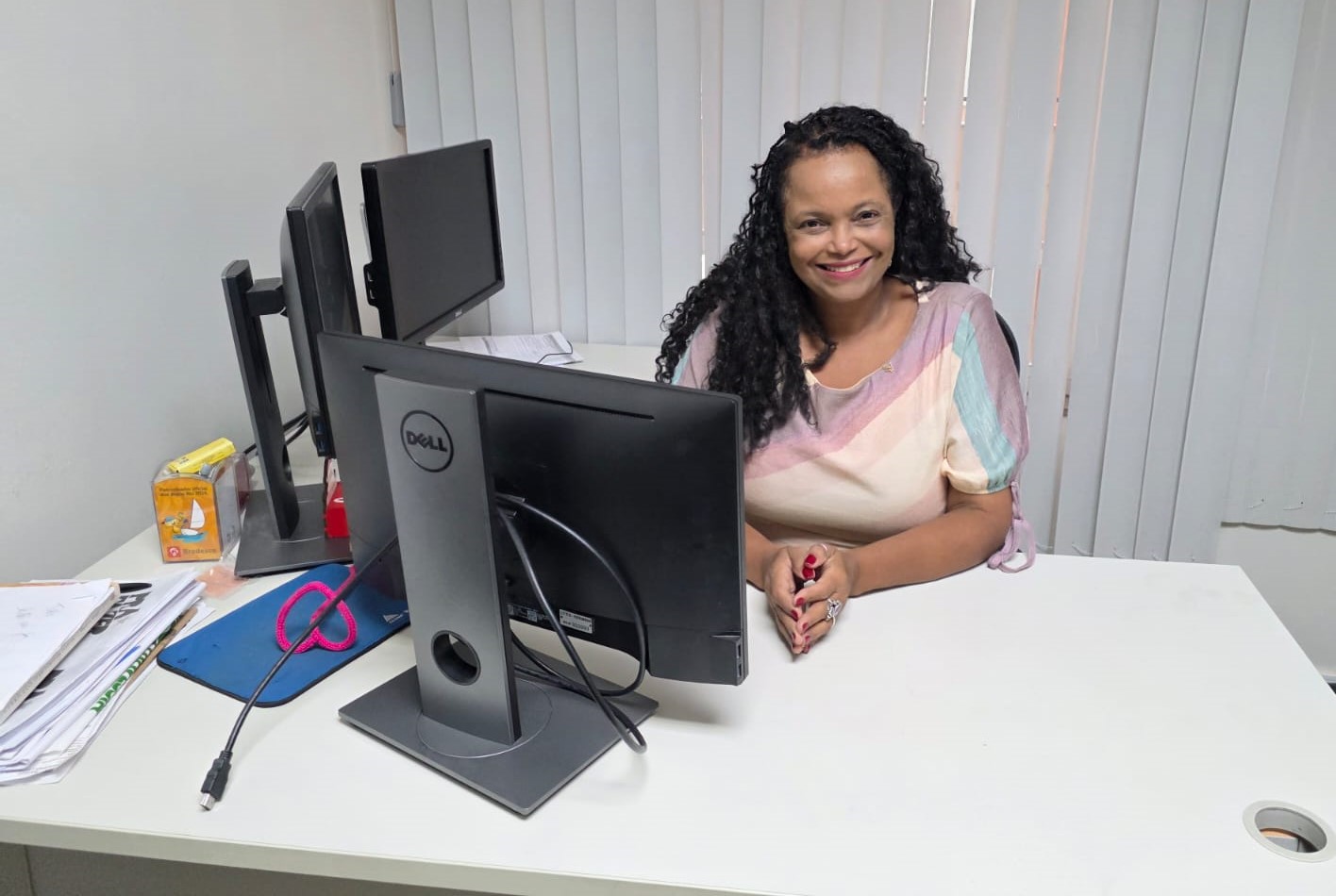 Foto da professora em sua mesa de trabalho