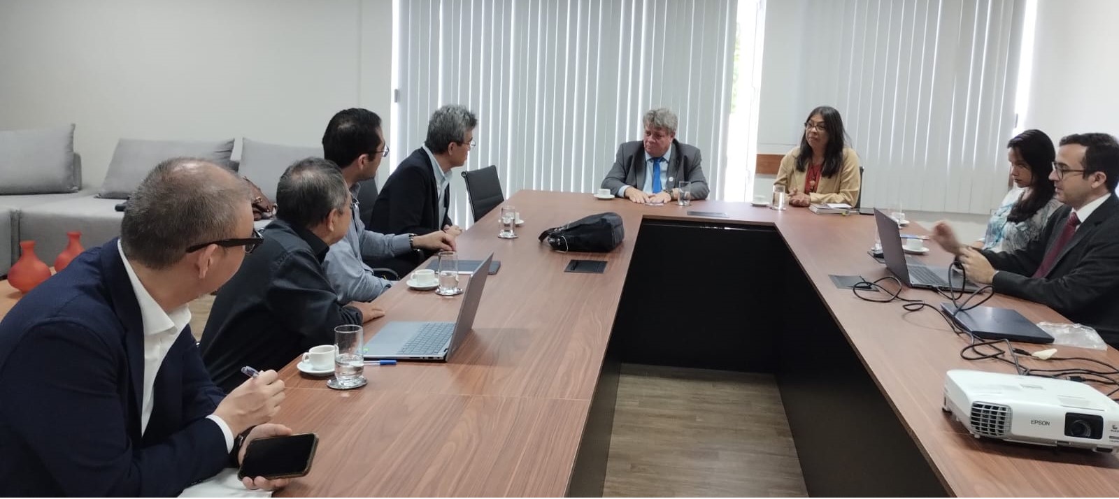 Foto da reunião com o reitor e a vice-reitora da Ufes, com todos sentados à mesa