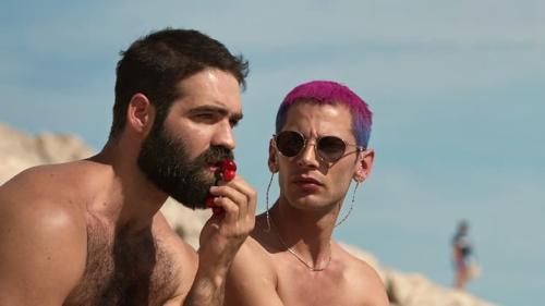 Cena de Nosso verão daria um filme que mostra dois rapazes sem camisa em uma praia.