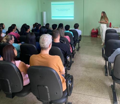 Foto de uma pesquisadora fazendo uma palestra sobre o tema em um auditório
