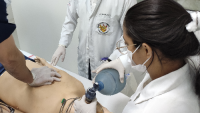 Foto de profissionais de saúde treinando um procedimento em um boneco