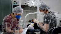 Foto de dentistas atendendo uma pessoa