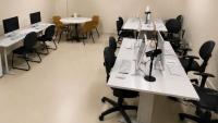 Foto geral do laboratório com mesas, computadores e microfones