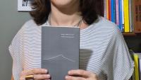 Foto da professora segurando o livro
