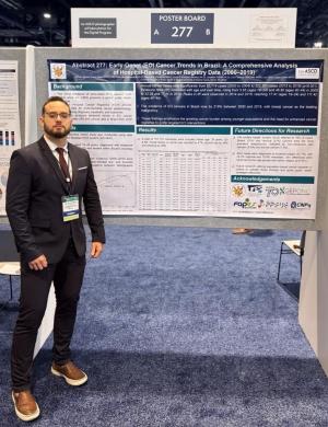 Foto do professor Luís Carlos Lopes-Júnior em frente ao poster apresentado pela Ufes