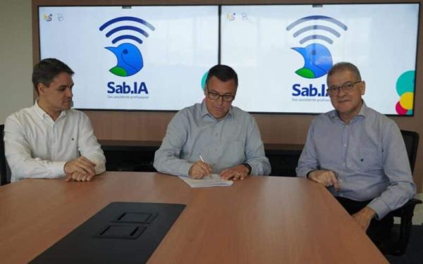 Foto com o diretor Vicente Duarte; o diretor-presidente do Banestes, José Amarildo Casagrande, assinando o contrato; e o professor Alberto de Souza.