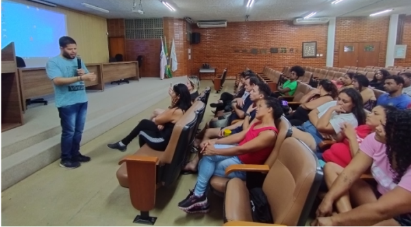 Foto do estudantes falando aos trabalhadores no auditório