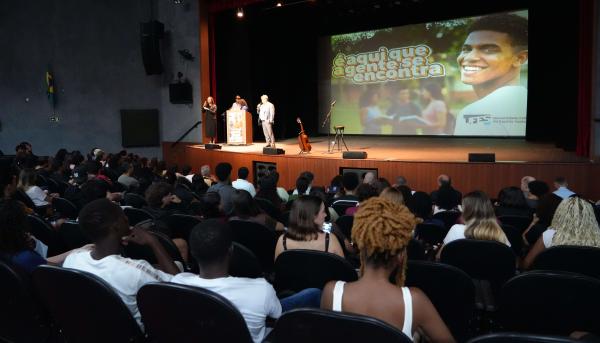 Foto do reitor falando para o público no Teatro lotado