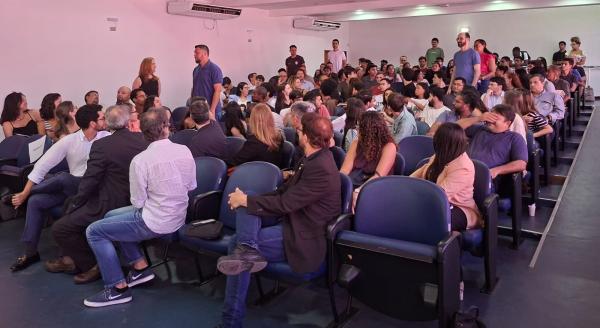 Foto do auditório cheio, com os alunos da primeira turma de doutorado em pé