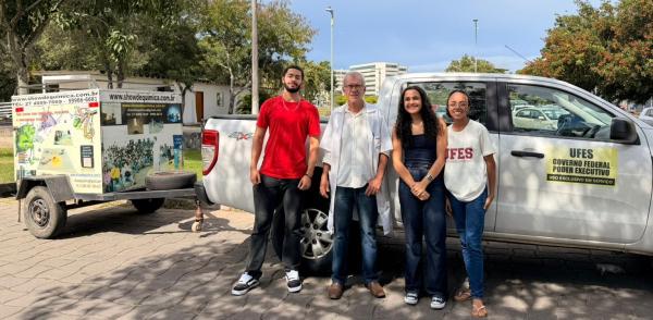 Foto do professor com estudantes do projeto na frente de um carro da Ufes