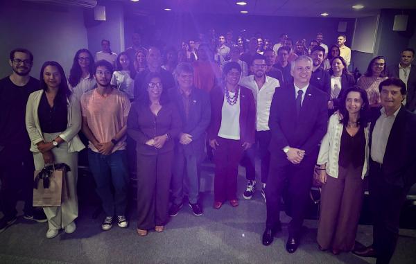 Foto dos participantes do encontro reunidos à frente do auditório