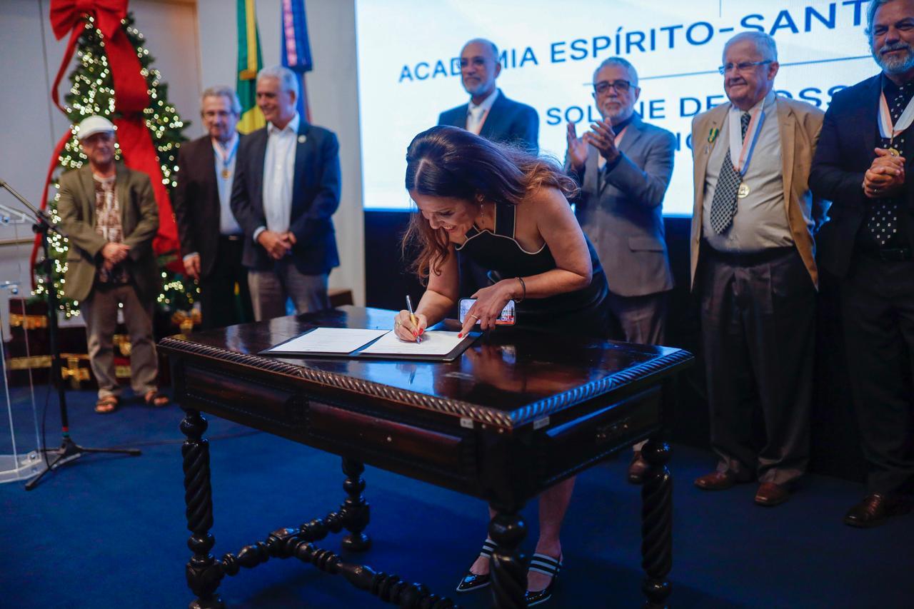 Foto da professora Adriana Campos assinando o livro de posse 