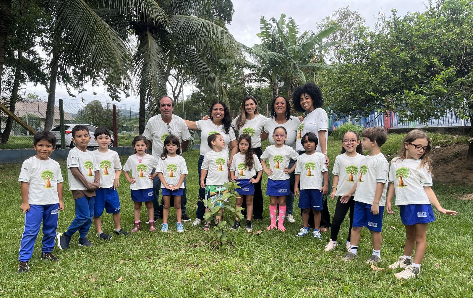 Foto dos alunos com os professores em um gramado
