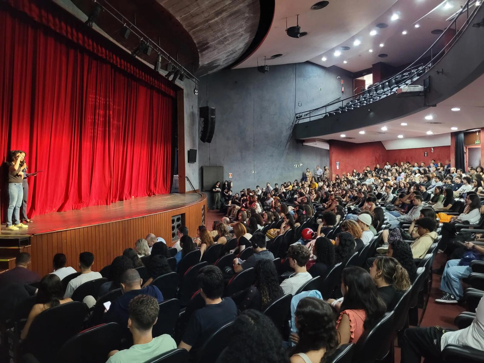 Foto de pessoas sentadas no interior do Teatro Universitário