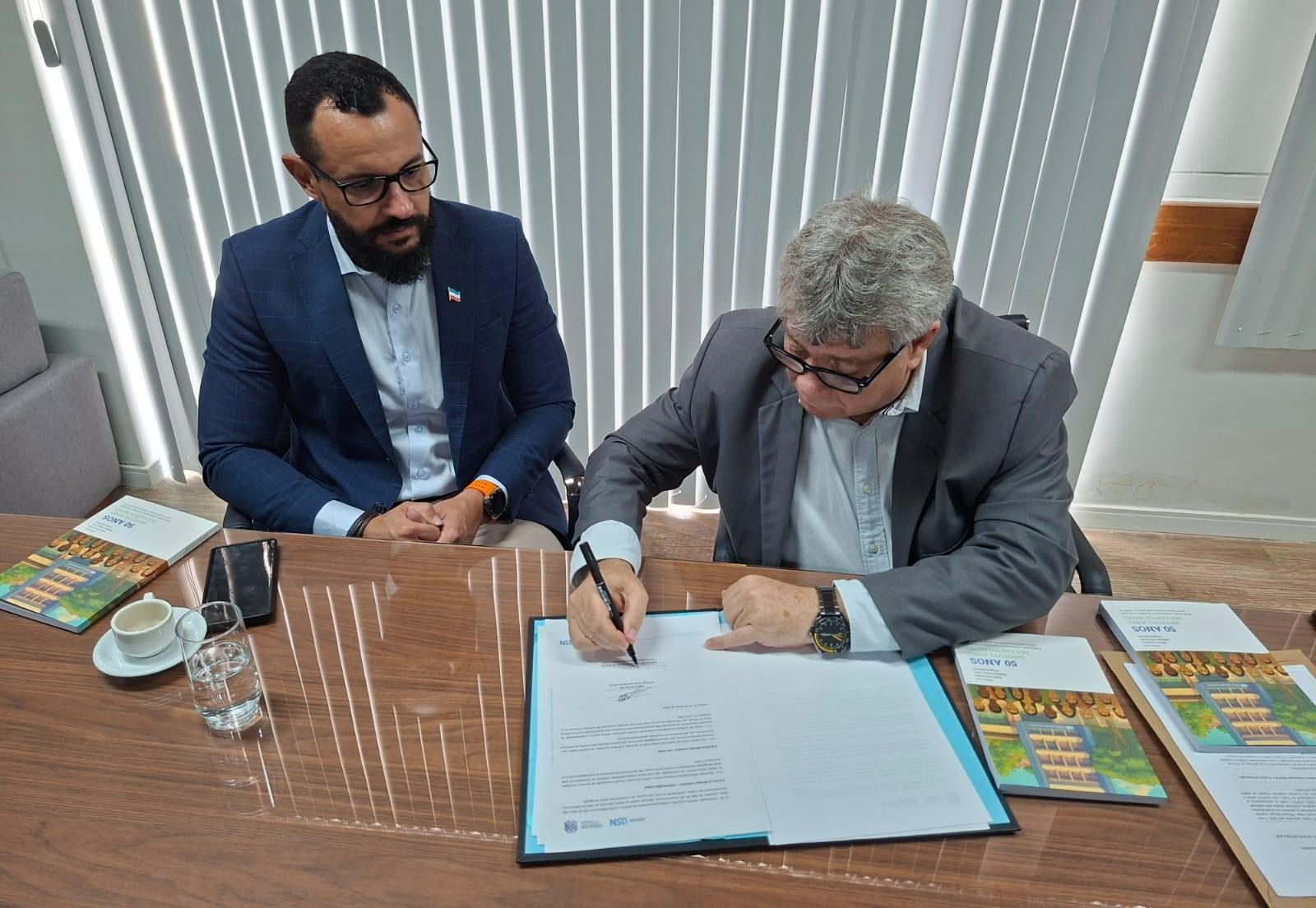 Foto de Pablo Lira e Eustáquio de Castro assinando o termo de cooperação