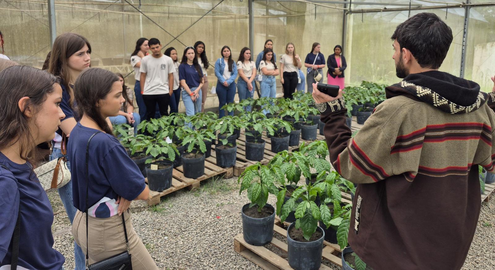 Foto dos estudantes visitando a estufa de mudas