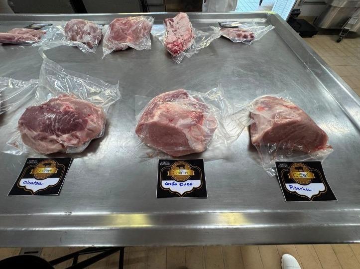 Foto de peças de carne suína em um balcão de frios