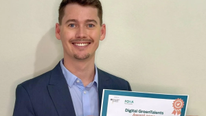 Foto do pesquisador segurando o certificado do prêmio