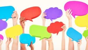 Imagem de diversos braços segurando balões de diálogos coloridos