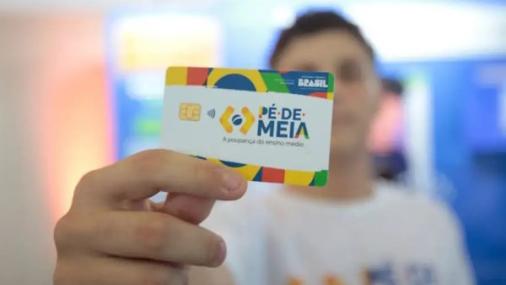 Imagem de um estudante segurando um cartão do programa Pé-de-Meia