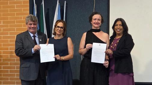 Foto das novas diretoras segurando o termo de posse ao lado do reitor e da vice-reitora